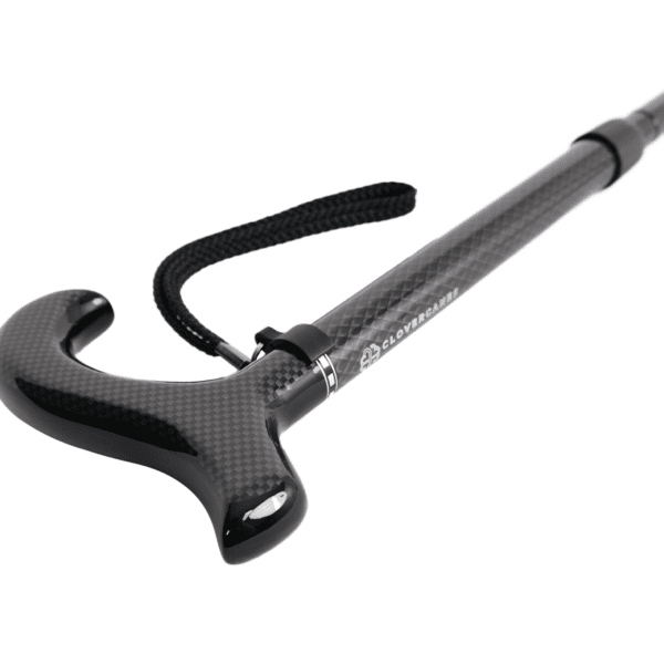 Ergonomic curved carbon-fiber trekking pole handle with a fabric wrist strap.
