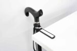 Close-up of a black curved prosthetic leg/peg with a textured grip mounted near a white desk surface.