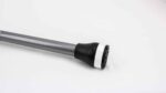 Close-up of a hockey stick shaft with a black wrapped grip and white tape near the end on a white background, lying diagonally.
