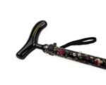 Black T-handle walking cane with a floral-patterned shaft and a wrist strap (close-up).