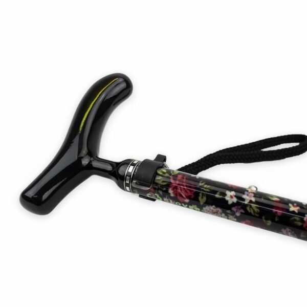 Black T-handle walking cane with a floral-patterned shaft and a wrist strap (close-up).